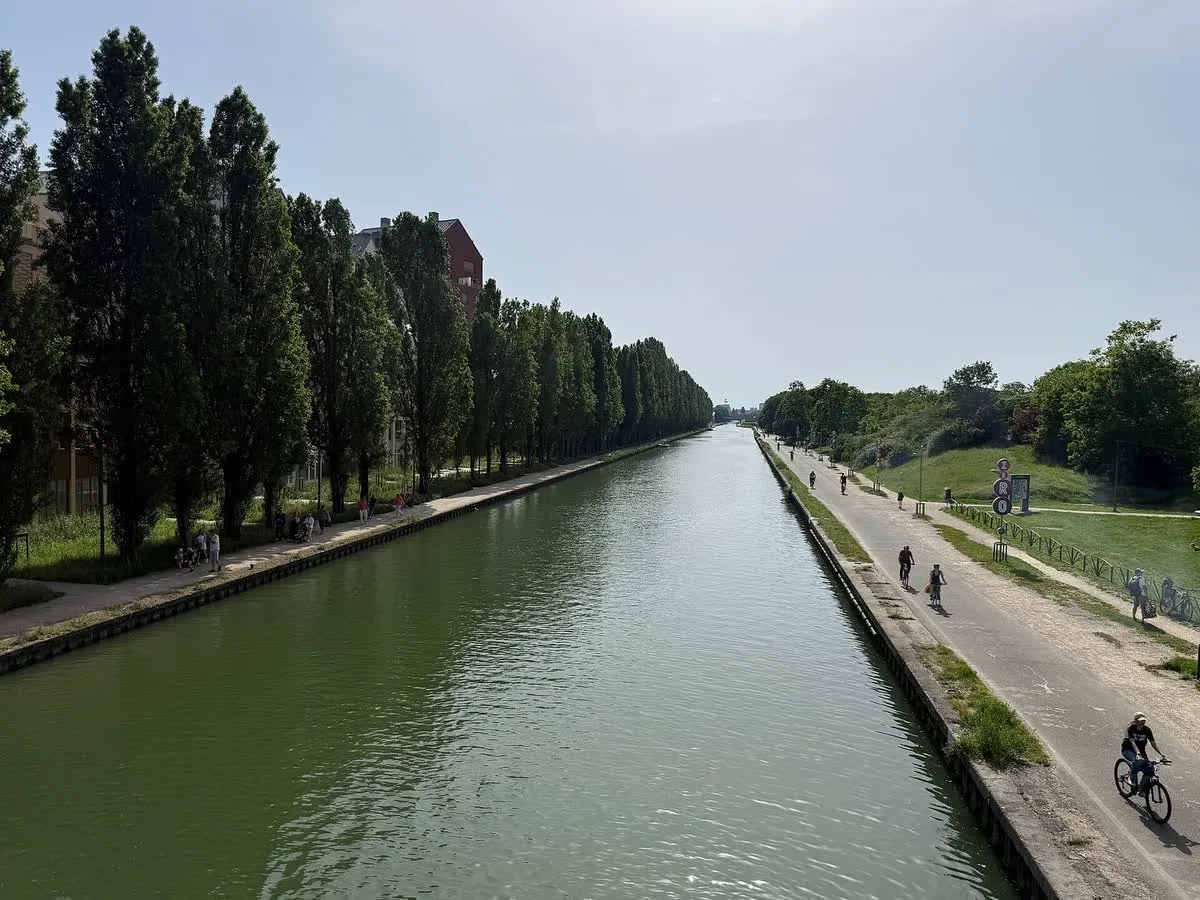 Le canal de l'Ourcq à Bobigny, bordé d'arbres, avec promeneurs et cyclistes sur ses berges aménagées